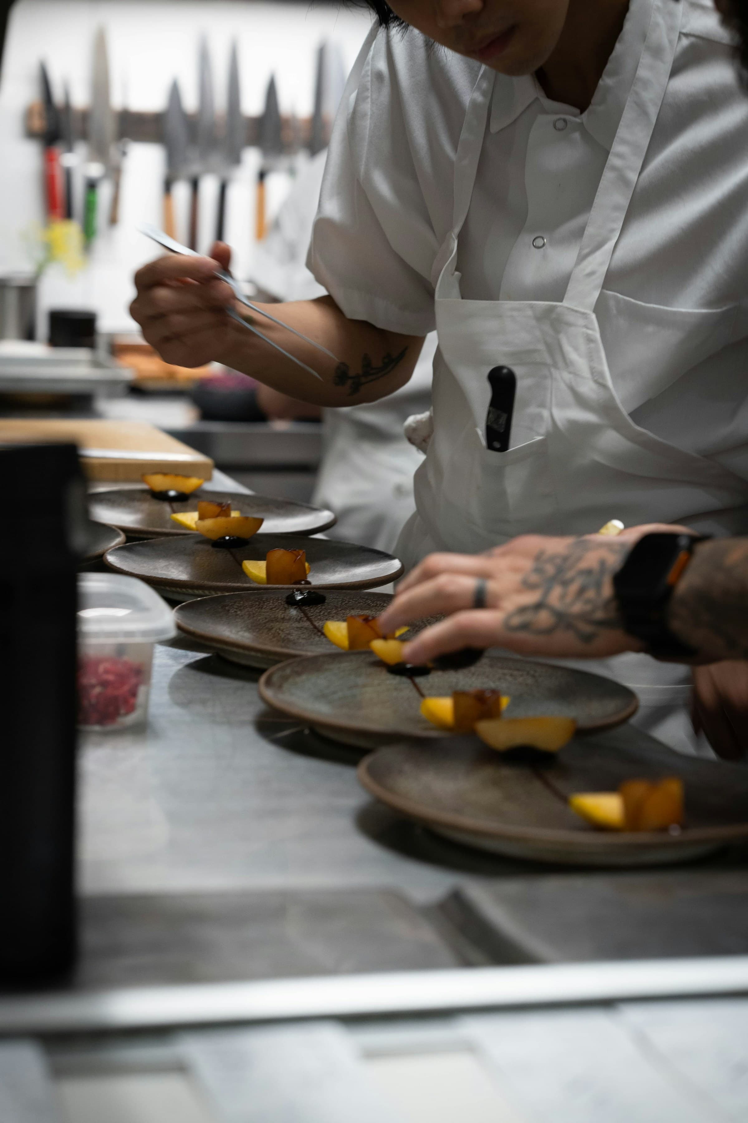 A chef plating a dessert in a professional kitchen