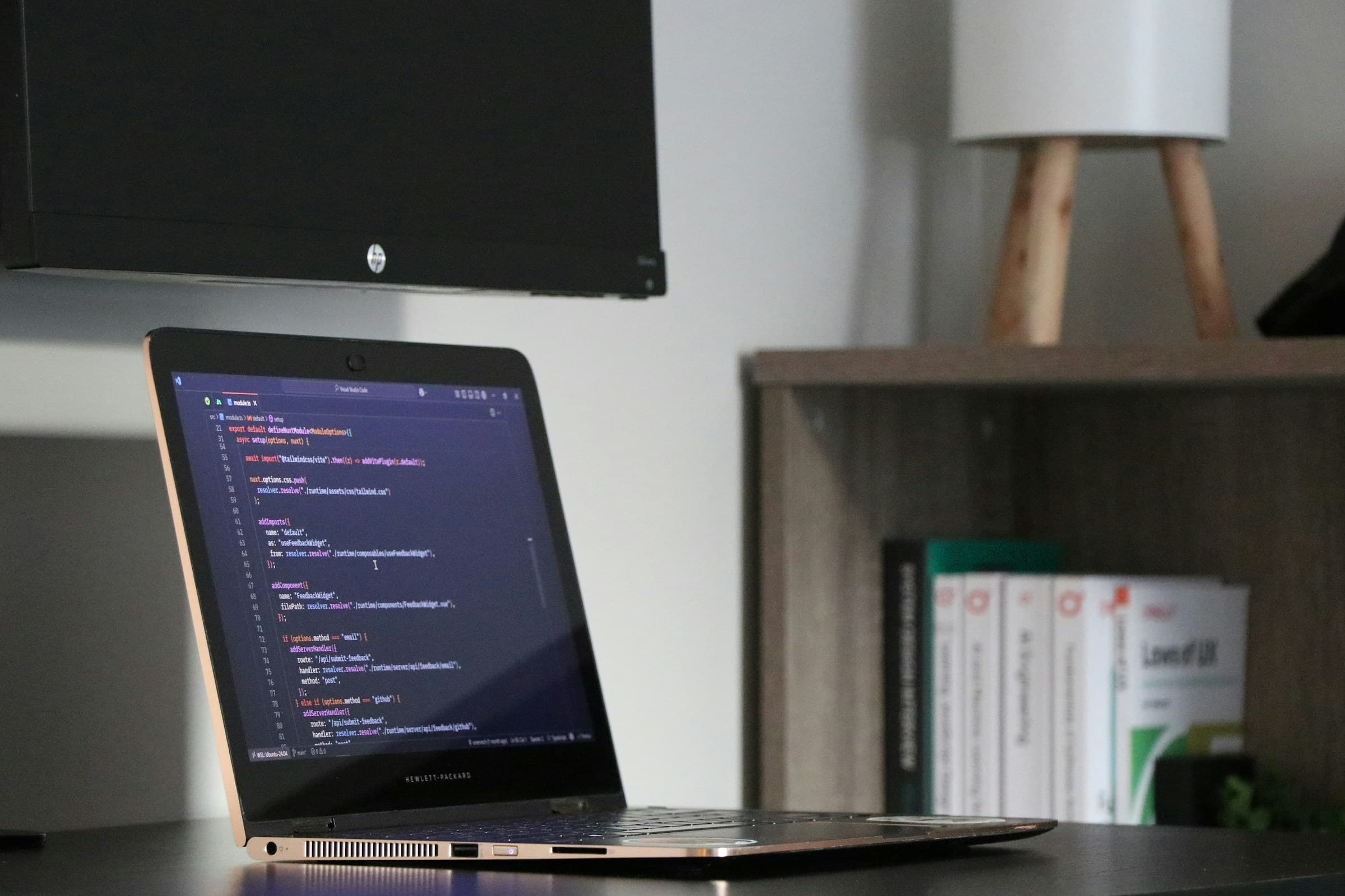 A laptop displaying code on a desk